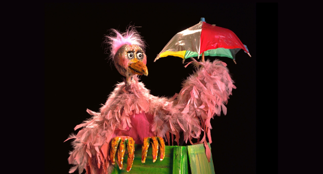 Roze vogelpop met bont parapluutje in de hand
