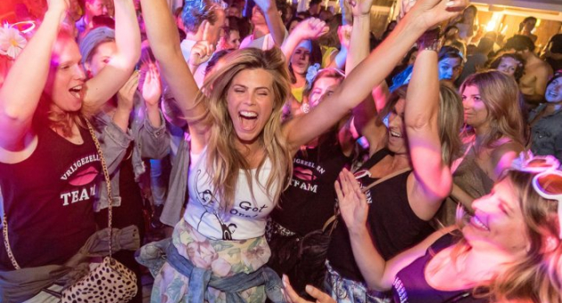 Feestende mensen die dansen en juichen op de dansvloer 