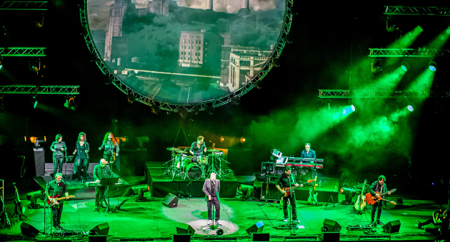 Pink Project The Band op een groen verlicht podium. 