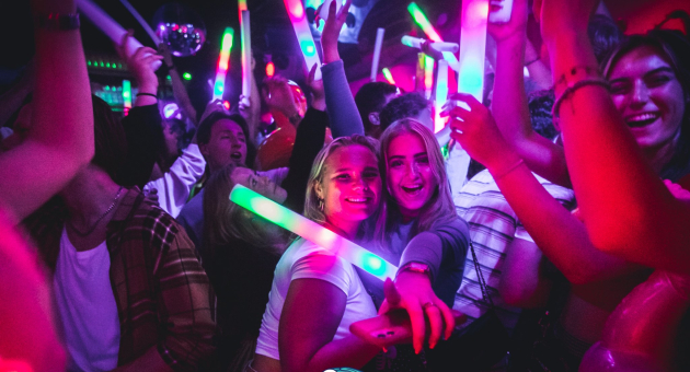 Jongeren feesten met lichtstaven in een club (foto Wouter Kouwenberg