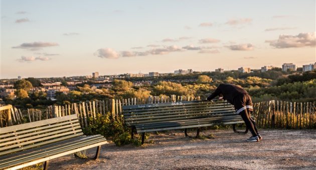 Sporter doet strekoefeningen in de duinen in het Westduinpark