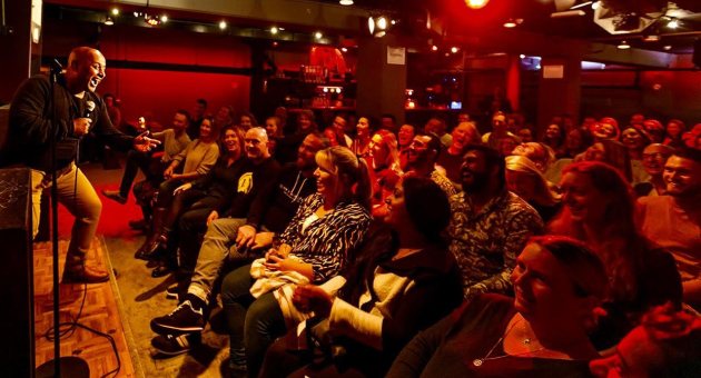 Comedian speelt voor lachend publiek in clubzaal