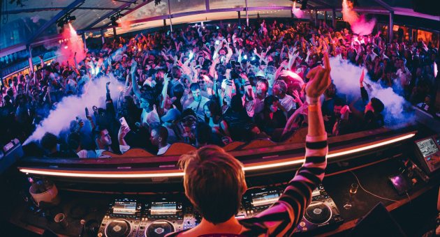 Drukke dansvloer met DJ in een feestelijke sfeer