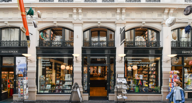 Vooraanzicht van De Vries Van Stockum in De Passage in Den Haag, met tijdschriften, kaarten en etalages vol boeken.