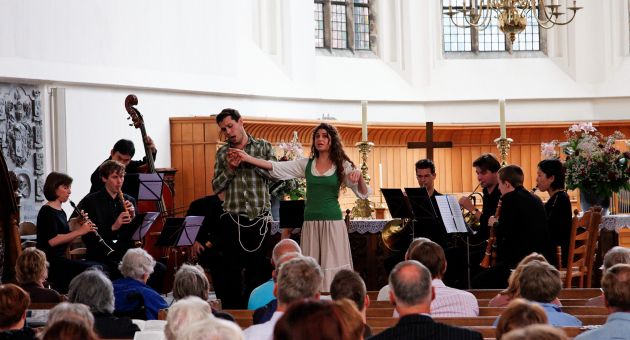 Een zangeres met band op het podium met publiek op de voorgrond