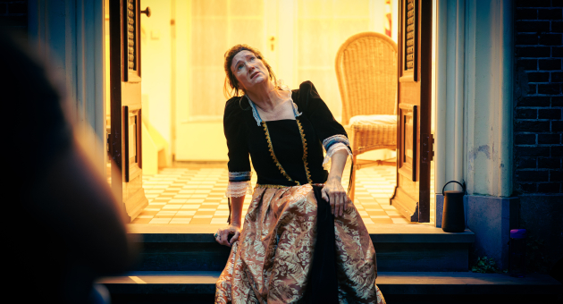 Dame leunt achterover op een trap in traditionele kleding