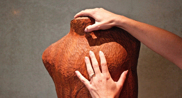 Twee handen op een sculptuur 