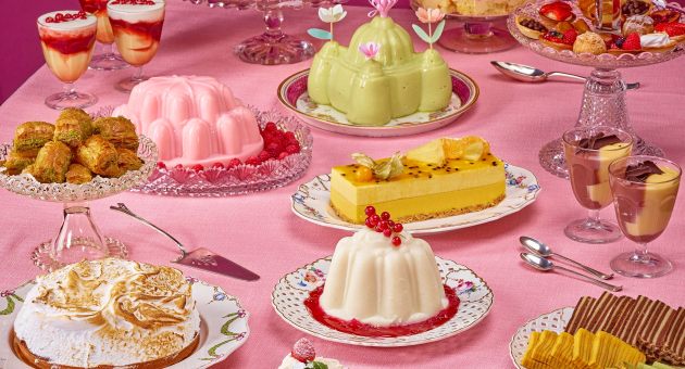 Een tafel vol met toetjes, taartjes en andere lekkernijen