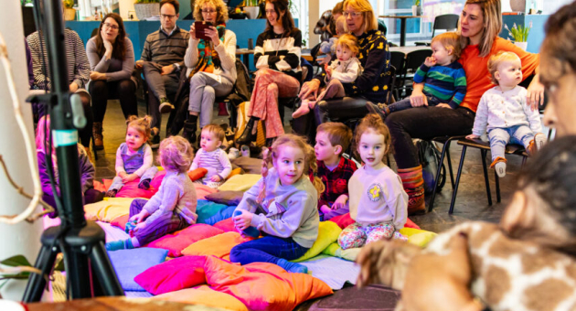 Kinderen en ouders luisteren naar een verhaal uit een boek