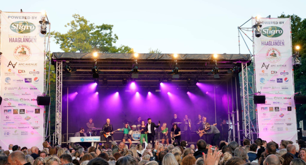 Podium met artiesten en een grote menigte 
