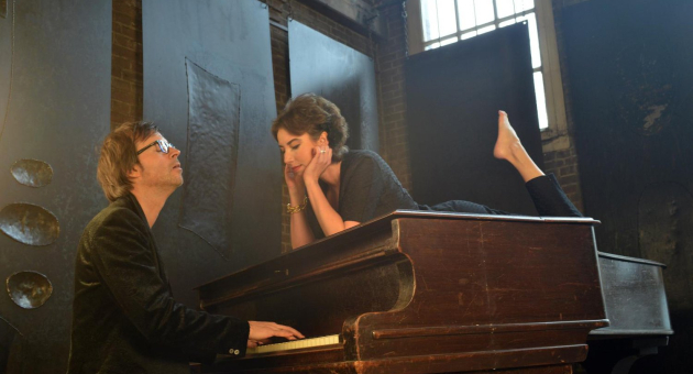 Britta Maria liggend op een piano en Maurits Fondse