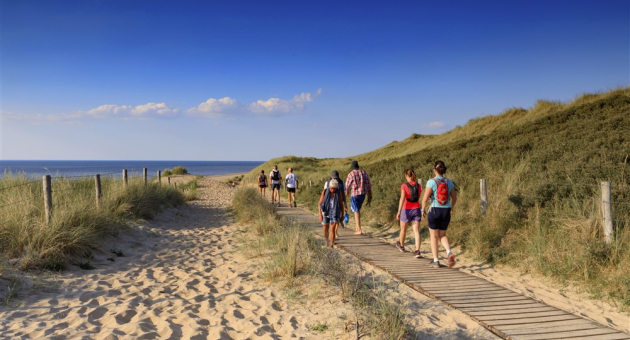 Groep mensen wandelt door de duinen van Scheveningen