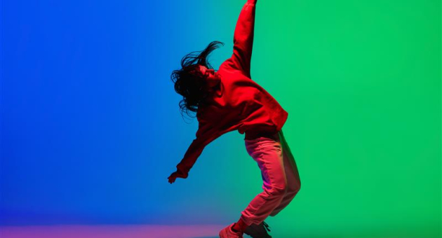 Vrouw maakt dansbeweging in kleurrijk licht