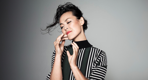 Portret van harpist Lavinia Meijer met sierlijke handen en zwart grijze achtergrond.