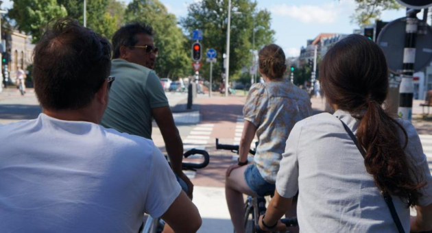 Groep fietsers wacht bij verkeerslicht in Den Haag