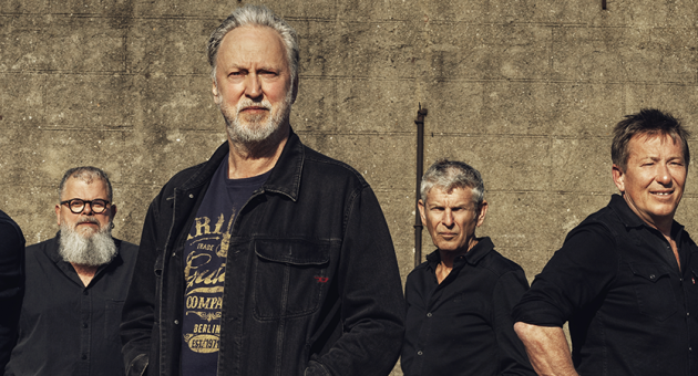 Band Rowwen Heze in zwart gekleed voor betonnen muur, ter prormotie van de Okemedoki tour