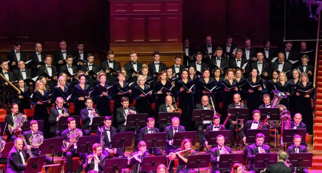 Orkest en koor voeren muziekstuk uit op podium (c) World Concerts 