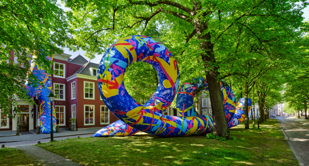 Kleurrijk kunstwerk op het Lange Voorhout tussen de bomen voor de gevel van Pulchri Studio