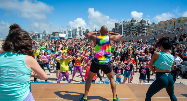 Mensen die een Zumba-workout doen op de boulevard van Scheveningen