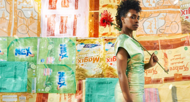 Vrouw in groene jurk met bloem voor kleurrijke muur (c) Marijke de Gruyter en Nicolien de Jong