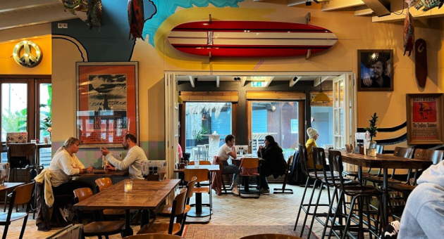 Het sfeervolle surfrestaurant van Hart Beach met houten tafels, kleurrijke surfdecoratie en relaxte vibe. Het sfeervolle surfrestaurant van Hart Beach met houten tafels, kleurrijke surfdecoratie en relaxte vibe.
