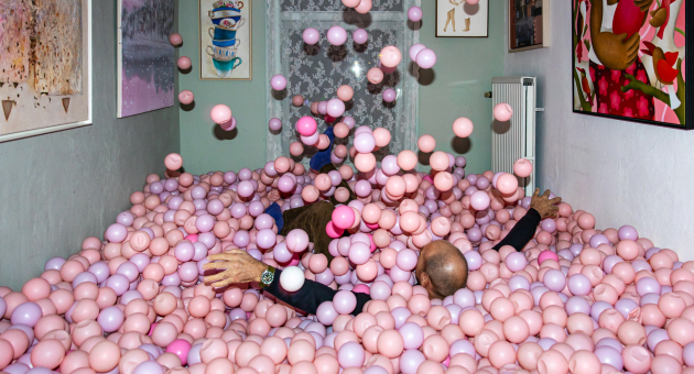 Volwassenen in kamer vol roze ballen