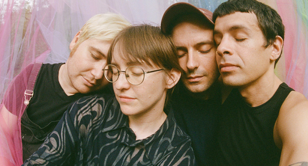 New Yorkse indiefolk bandleden leunend tegen elkaar met dichte ogen voor kleurrijke voile gordijnen.