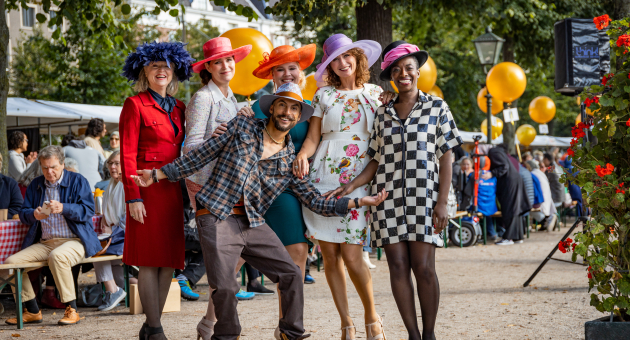 Groep mensen in kleurrijke outfits en hoeden ©Jelle Mes