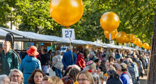 Drukke marktkramen en mensen zittend aan tafel voor het PrinsjesOntbijt