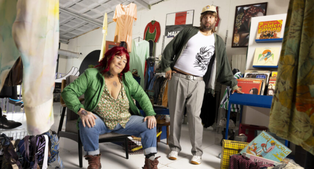 Twee mensen in vintagewinkel tussen kleding en platen