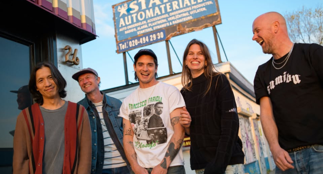 Band Mich vrolijk on the road met billboard op de achtergrond.