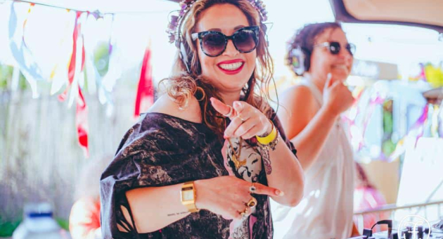 Vrouwelijke DJ lacht en draait op beachparty (c) Femmazing at the Beach