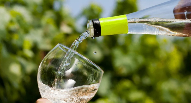 Witte wijn wordt in glas geschonken buiten