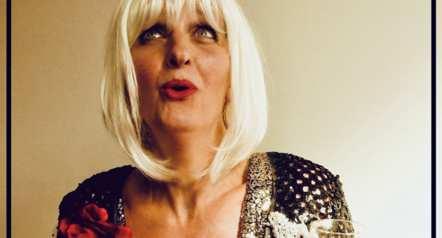 Vrouw in glitterjurk met blond haar en glas wijn