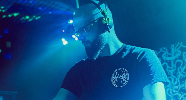 DJ Demanufacturer achter dj-set in blauw licht.
