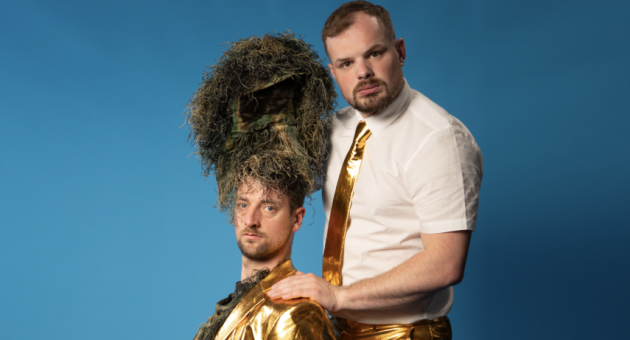 Twee mannen in goudkleding, één met helm van gras