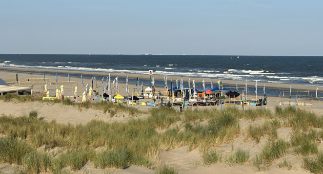 Zicht vanaf de duinen Kijkduin op het strand met de volleybalnetten.