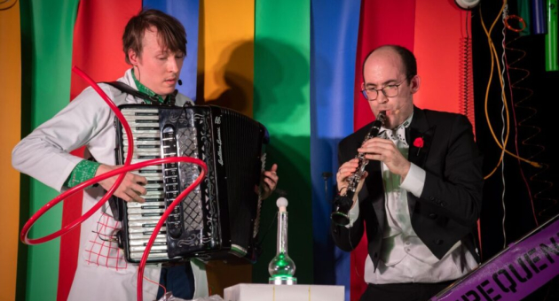Twee muzikanten spelen accordeon en klarinet op podium
