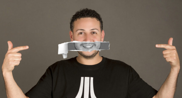 Man met papieren glimlachstrook voor zijn mond