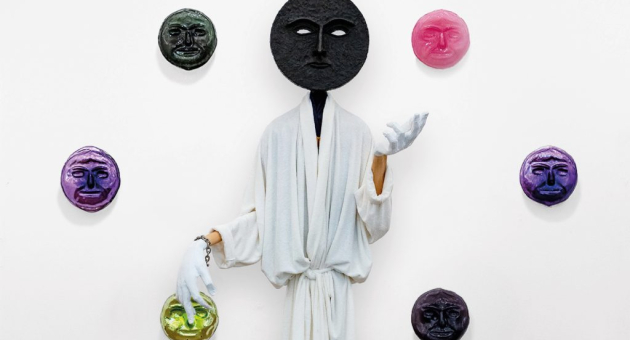 Kunstwerk figuur met zwart masker en gekleurde maskers