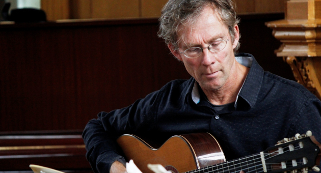 Gitarist speelt klassiek stuk op akoestische gitaar