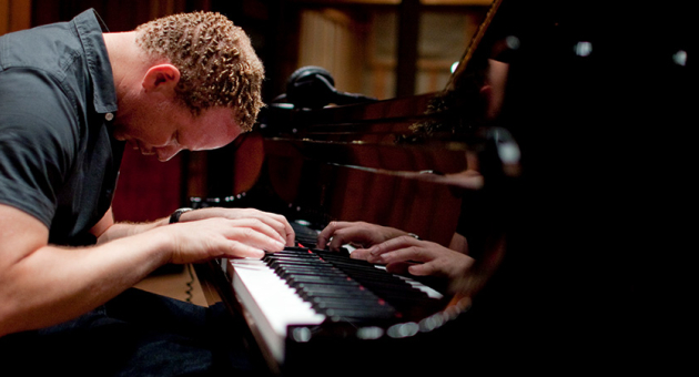 Pianist Craig Taborn voorover gebogen over zijn piano wat emotie en inleving toont.