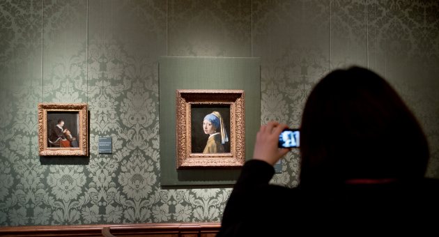 Foto van iemand die een foto maakt van het schilderij Meisje met de parel in het Mauritshuis