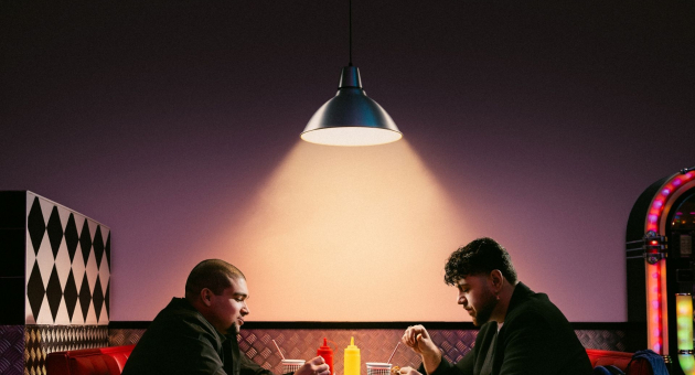 Twee mannen eten stil in een retro diner