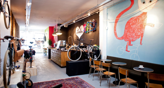 Industriele interieur van Lola bikes & coffee Den Haag met koffiebar en fietsen aan de muur