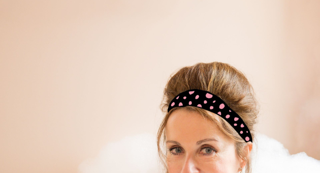 Close-up van een lachende Annick Boer in een bad vol schuim. 