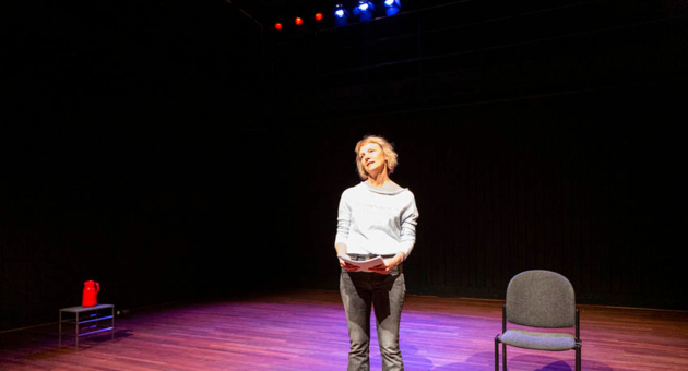 Vrouw op toneel met script in spotlight