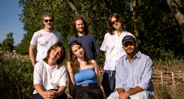 De 6 leden van de band Eeden music. 2 vrouwen en een man zitten op de voorgrond. 1 vrouw en 2 mannen staan erachter