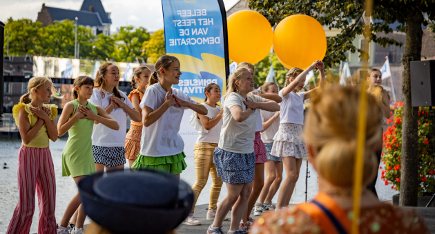 Meisjes dansen met ballonnen nabij de Hofvijver.