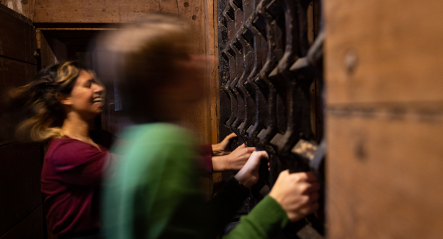 Kinderen in de gevangenis in Rijksmuseum de Gevangenpoort rammelen aan het hek.